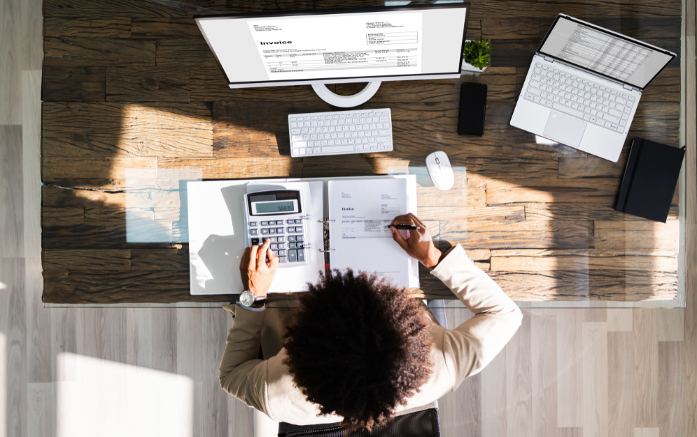 Vrouw werkt geconcentreerd aan haar bureau met laptop en documenten